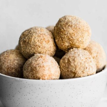 caramel snickerdoodle protein balls stacked in a white bowl
