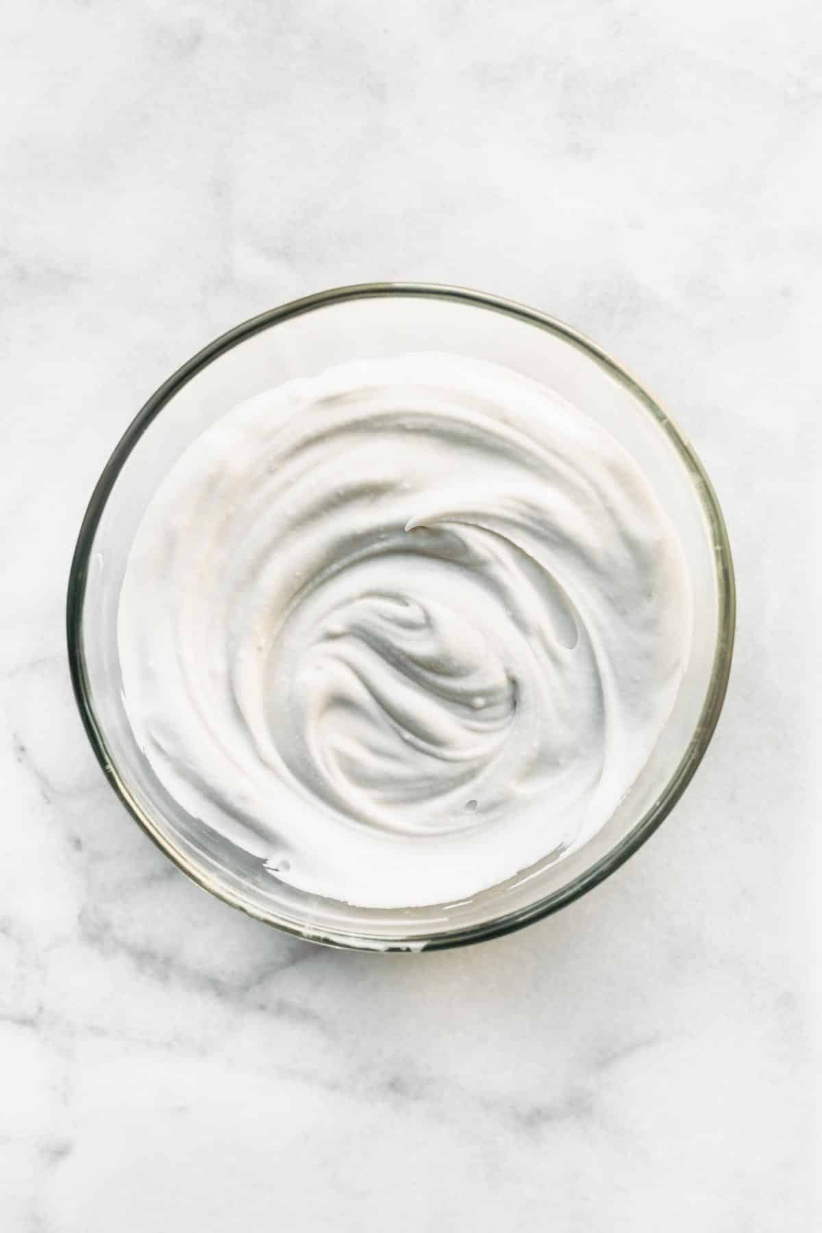 whipped coconut cream in a large glass mixing bowl