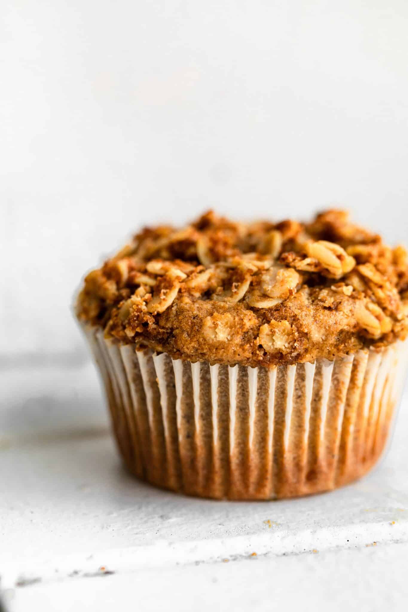 Up close photo of a fluffy honey ricotta muffin in a paper liner.