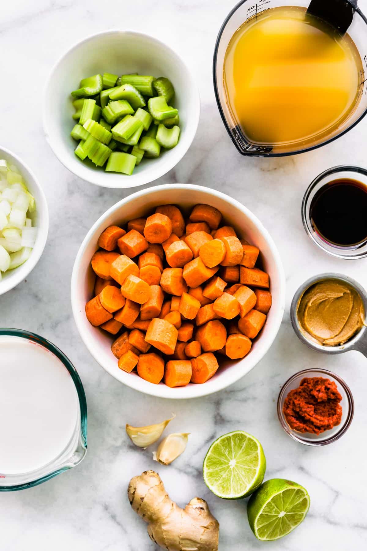 Diced carrots, celery, ginger and broth with other ingredients for Thai curried soup.