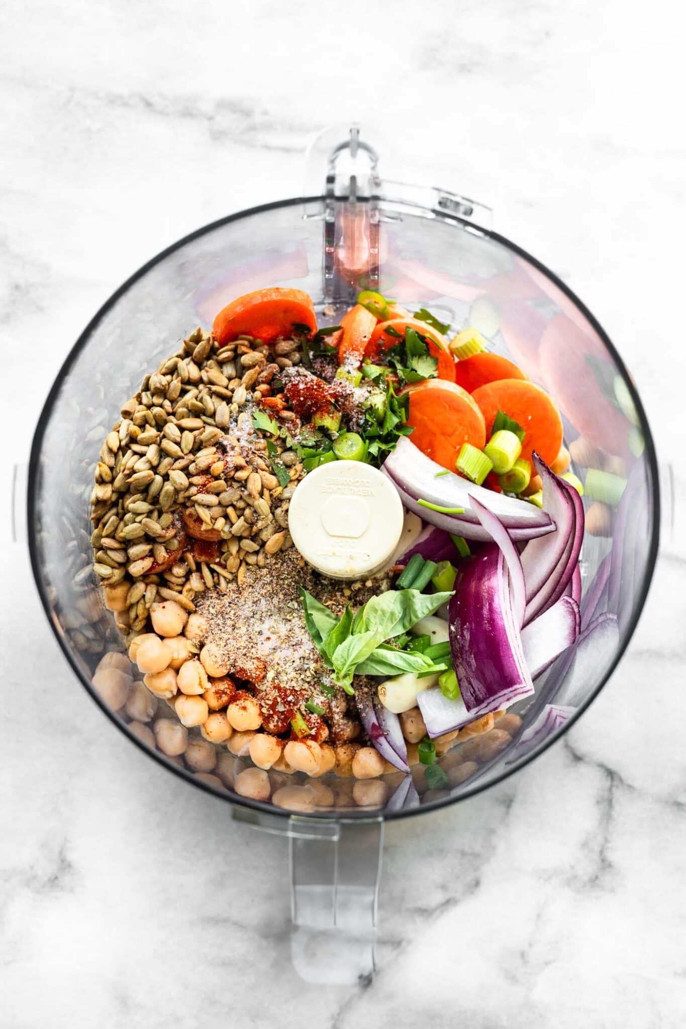 Chickpeas, sunflower seeds, carrots, red onion and herbs in a food processor.