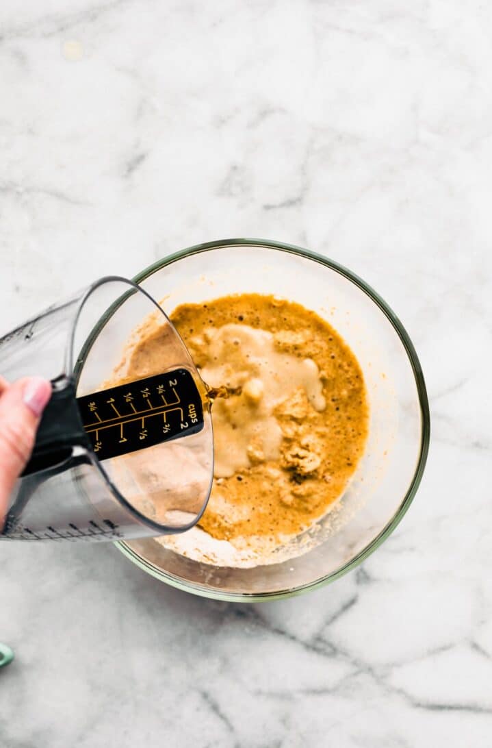 Seltzer being slowly poured into a bowl of gluten-free batter.