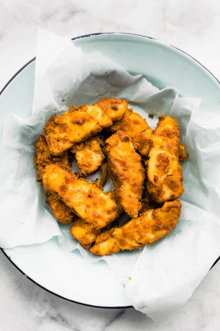 A basket of gluten-free beer-battered air fryer fish pieces.