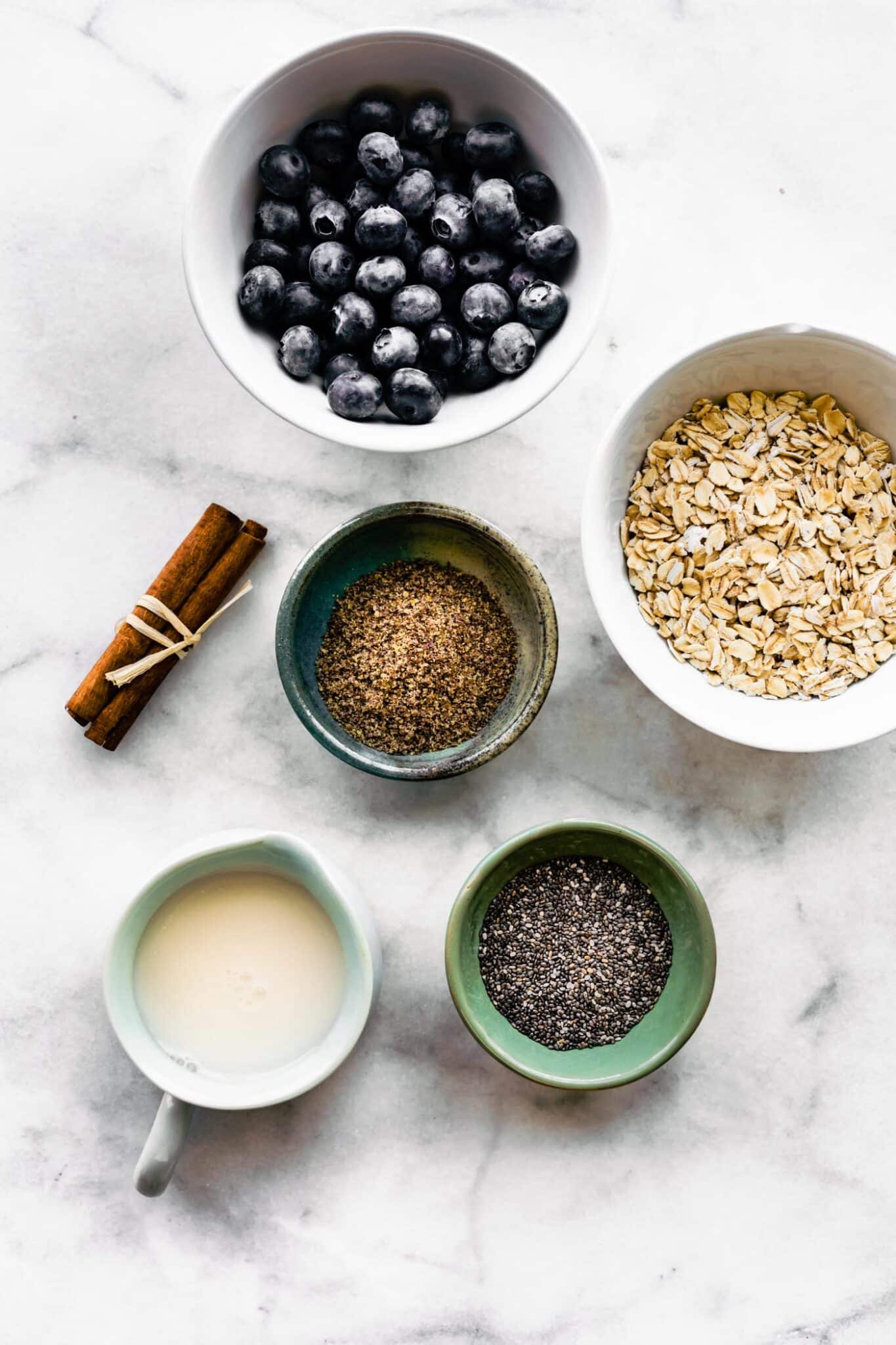 ingredients in bowls for blueberry overnight oats with chia and flaxmeal and cinnamon