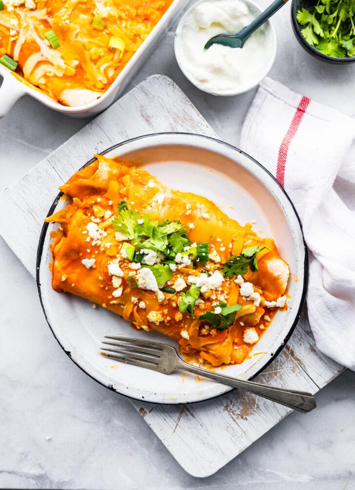2 spicy enchiladas on plate with fork