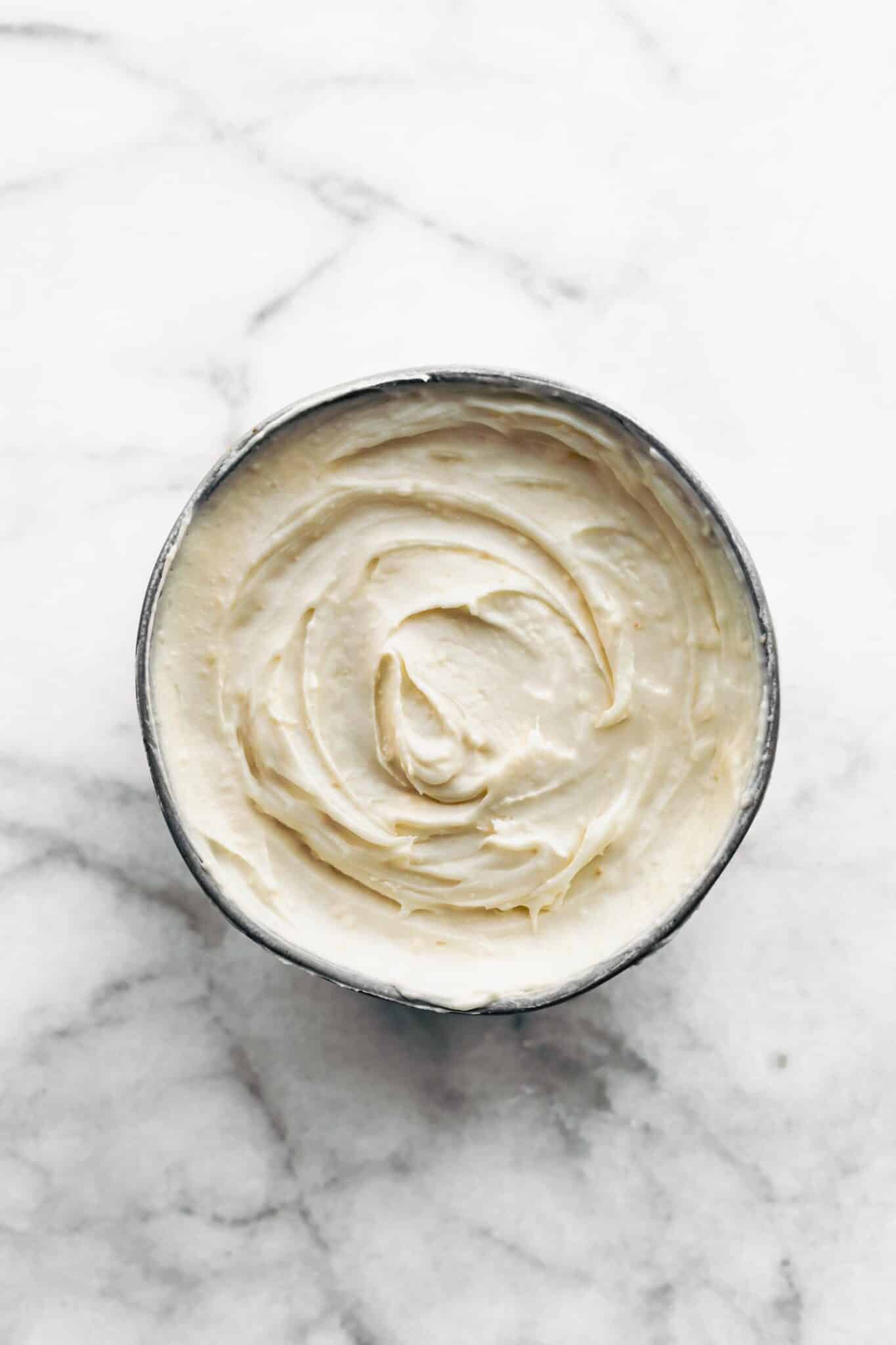 cream cheese frosting in a grey bowl.
