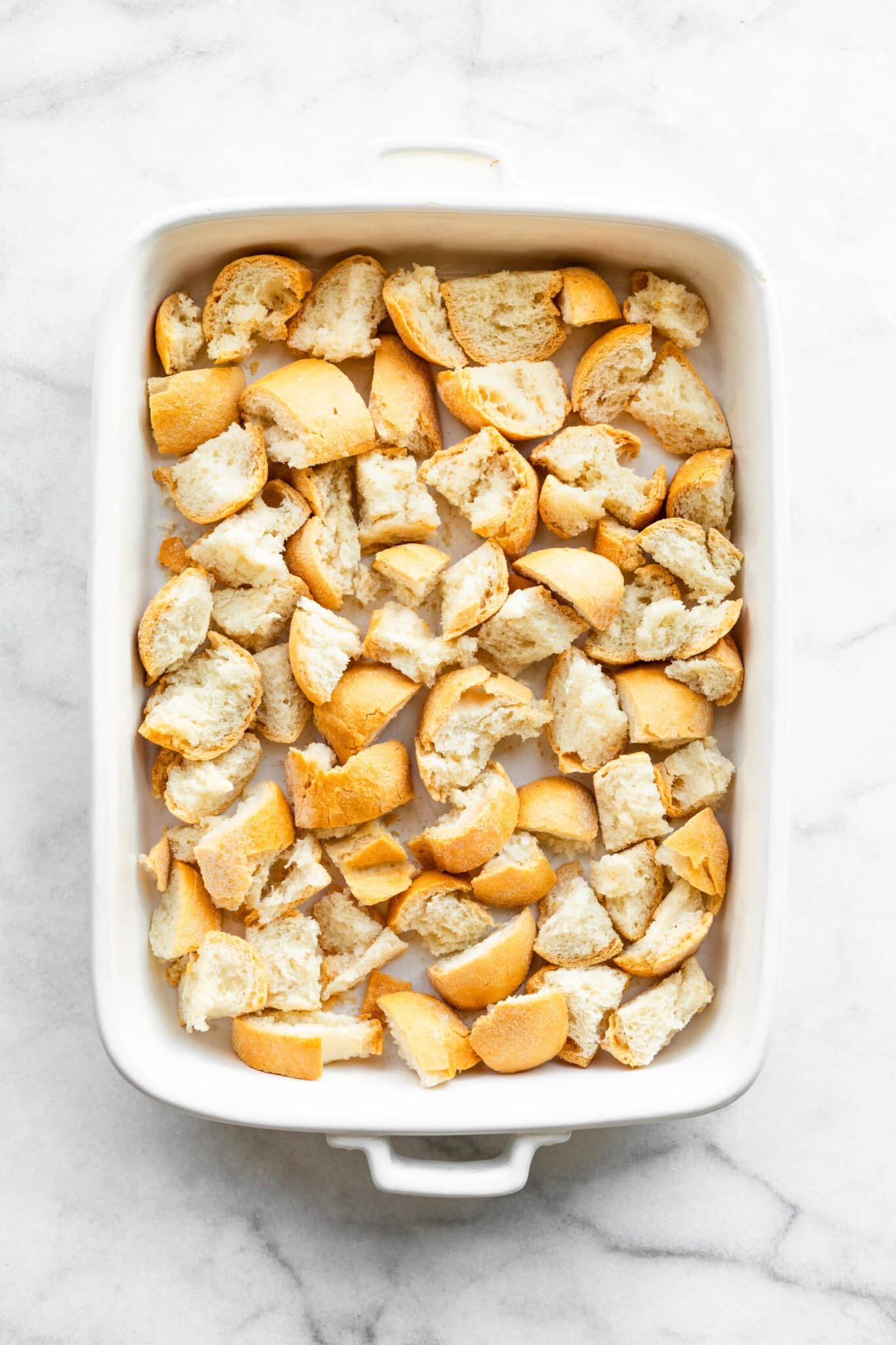 Overhead photo of a white baking pan filled with diced gluten free bread.