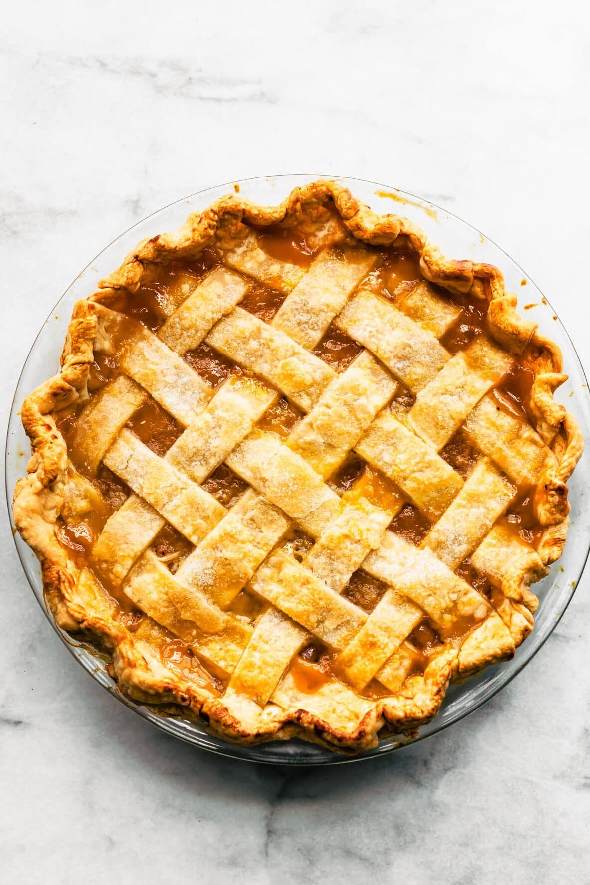 Golden apricot pie with a lattice crust, baked in a clear glass pie dish.