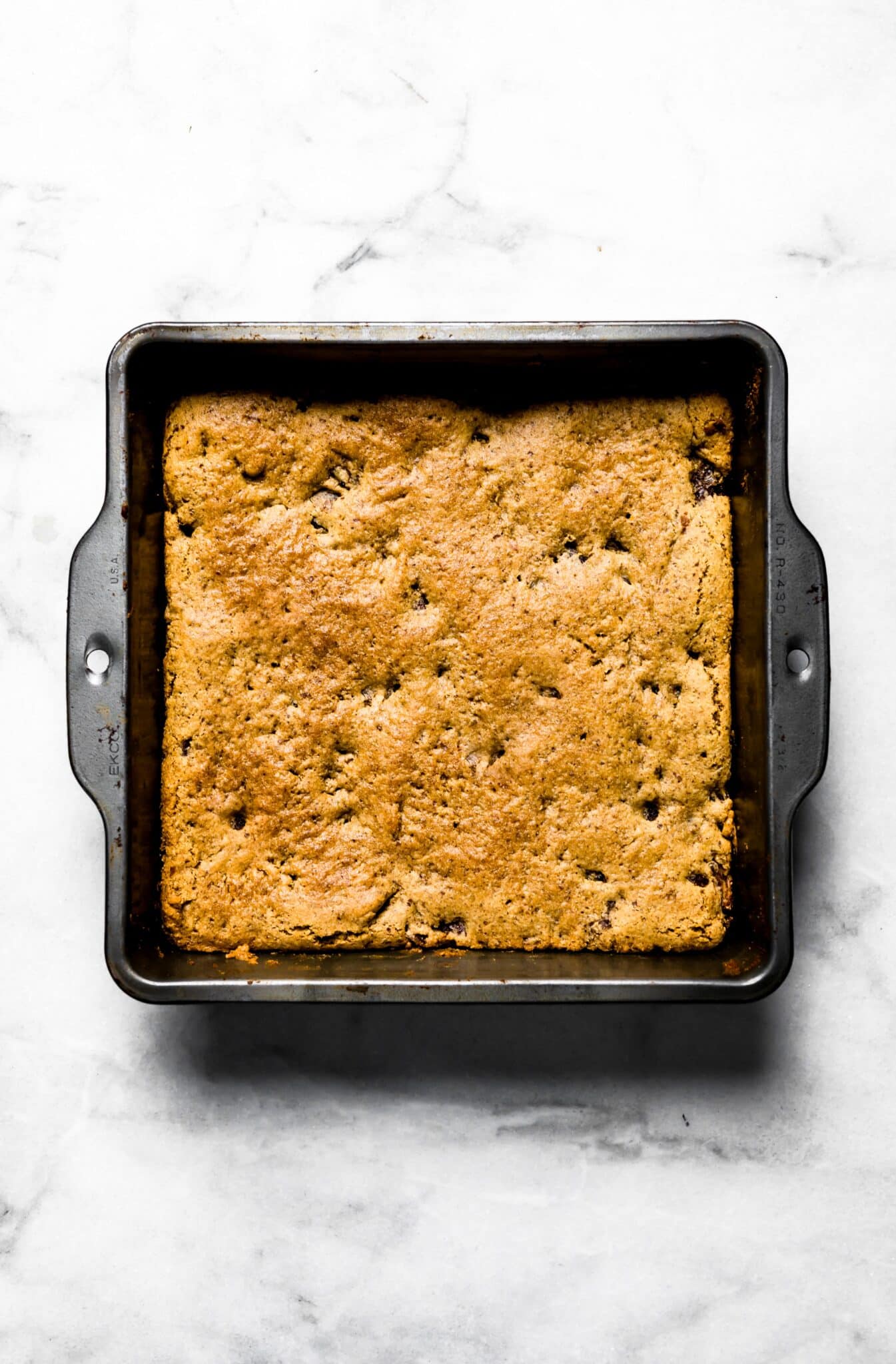 Overhead photo of soft baked paleo bars in a square metal baking pan.