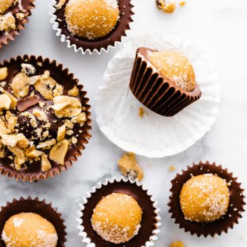 vegan edible cookie dough chocolate cups, some topped with nuts
