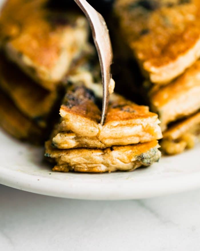 close up photo: fork cutting into a stack of vegan and dairy free pancakes