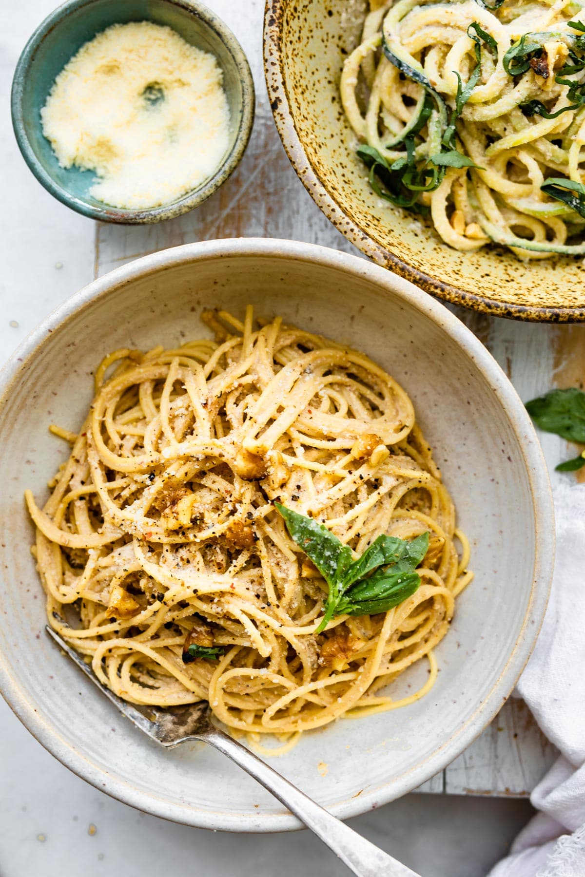 fork in bowl of spaghetti with walnut sauce over it