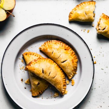 Overhead photo of three gluten free apple hand pies on a white plate.