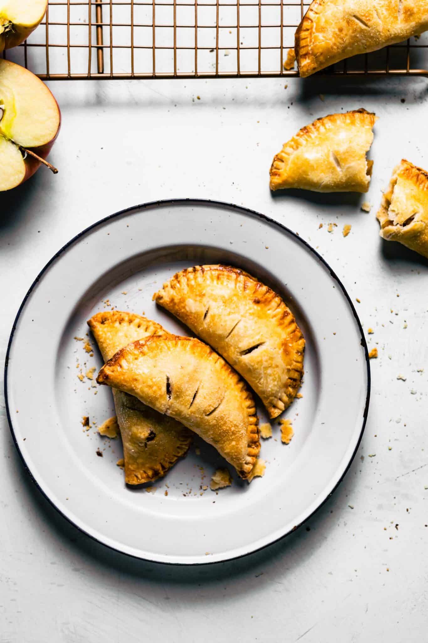 Overhead photo of three gluten free apple hand pies on a white plate.