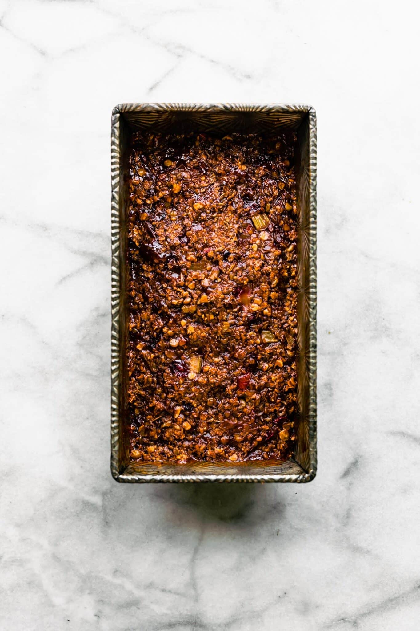 Overhead photo of a baked lentil loaf in a vintage metal pan with glaze