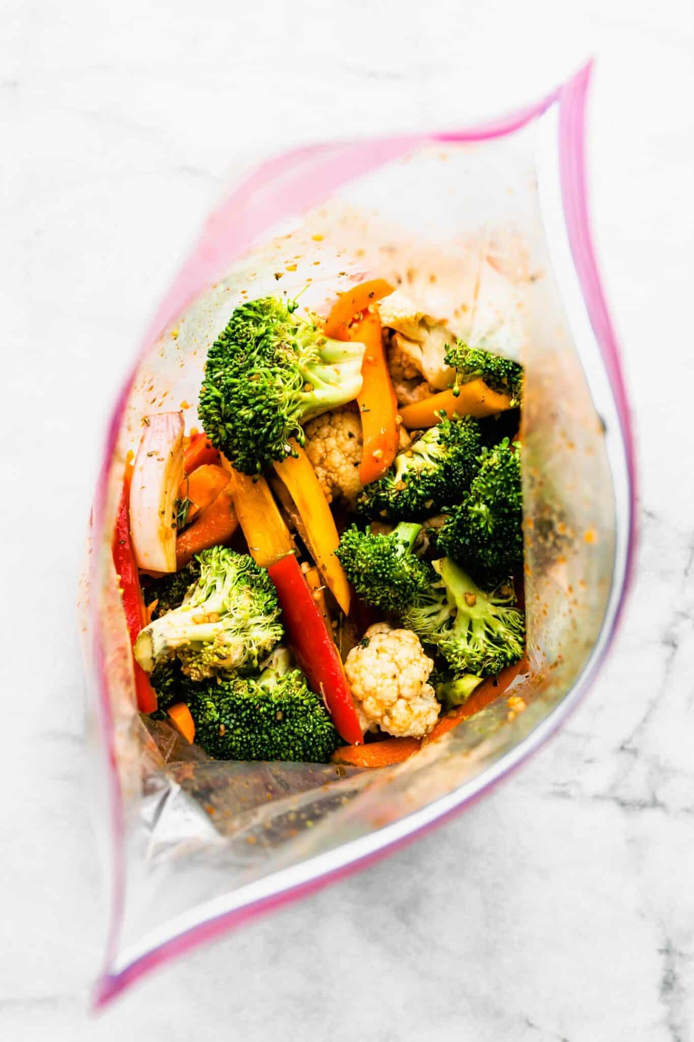 Overhead photo looking into a gallon sized storage bag with marinated veggies.