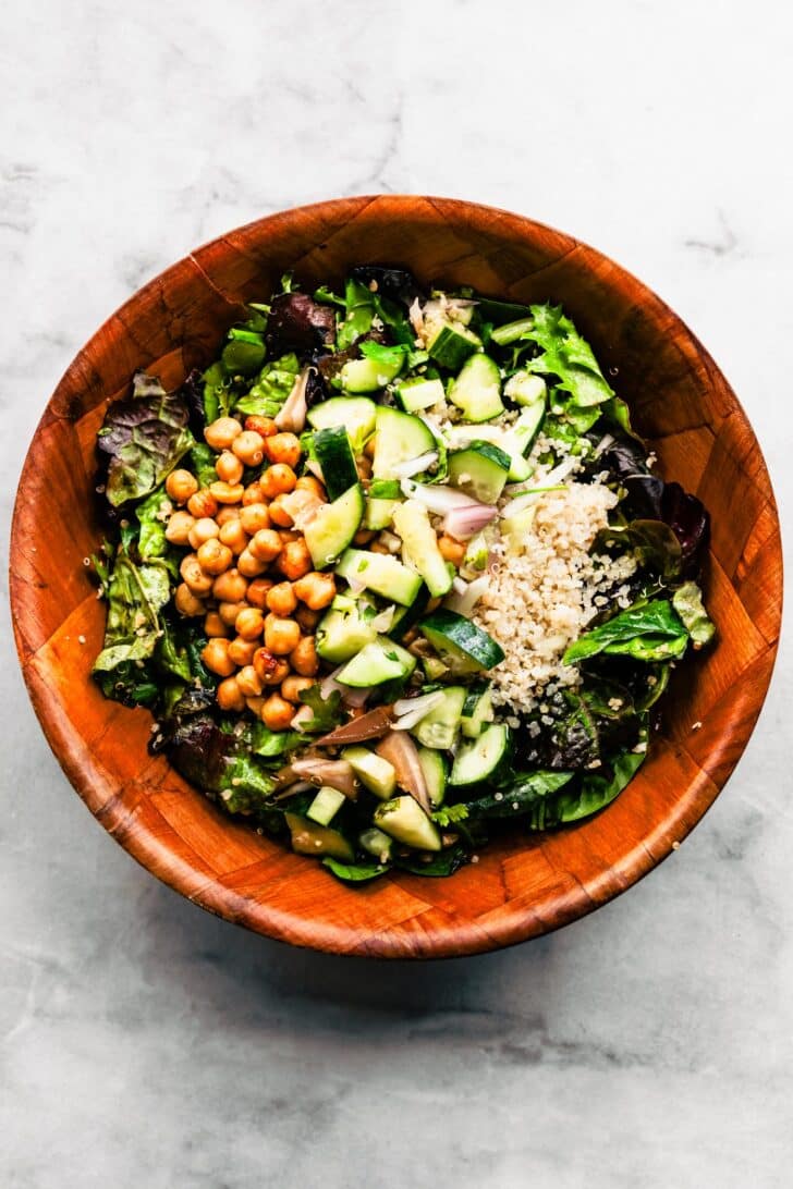 Overhead view salad with quinoa and chickpeas and fresh cucumber without dressing, in a bowl
