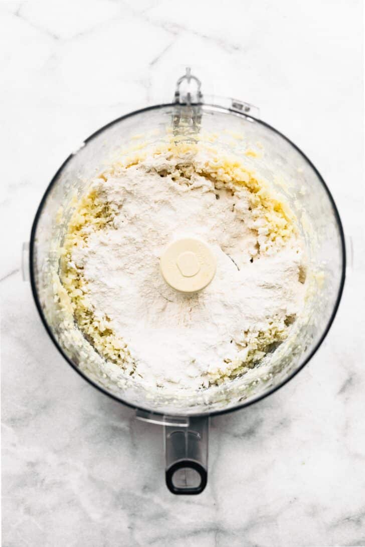 Potato starch on top of rice cauliflower in a food processor.