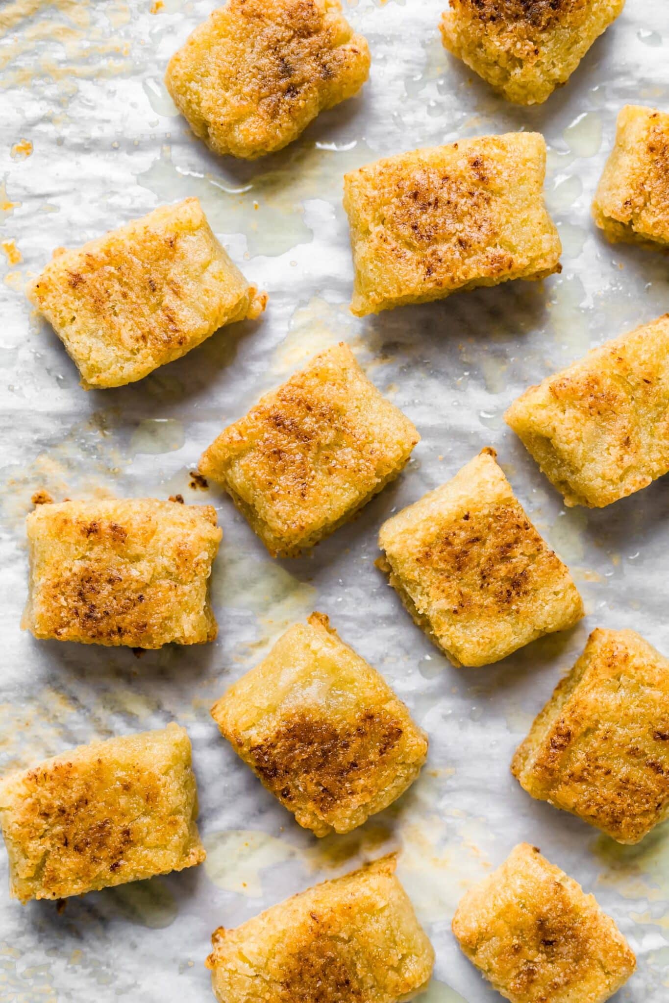 Golden brown cauliflower gnocchi on parchment paper.