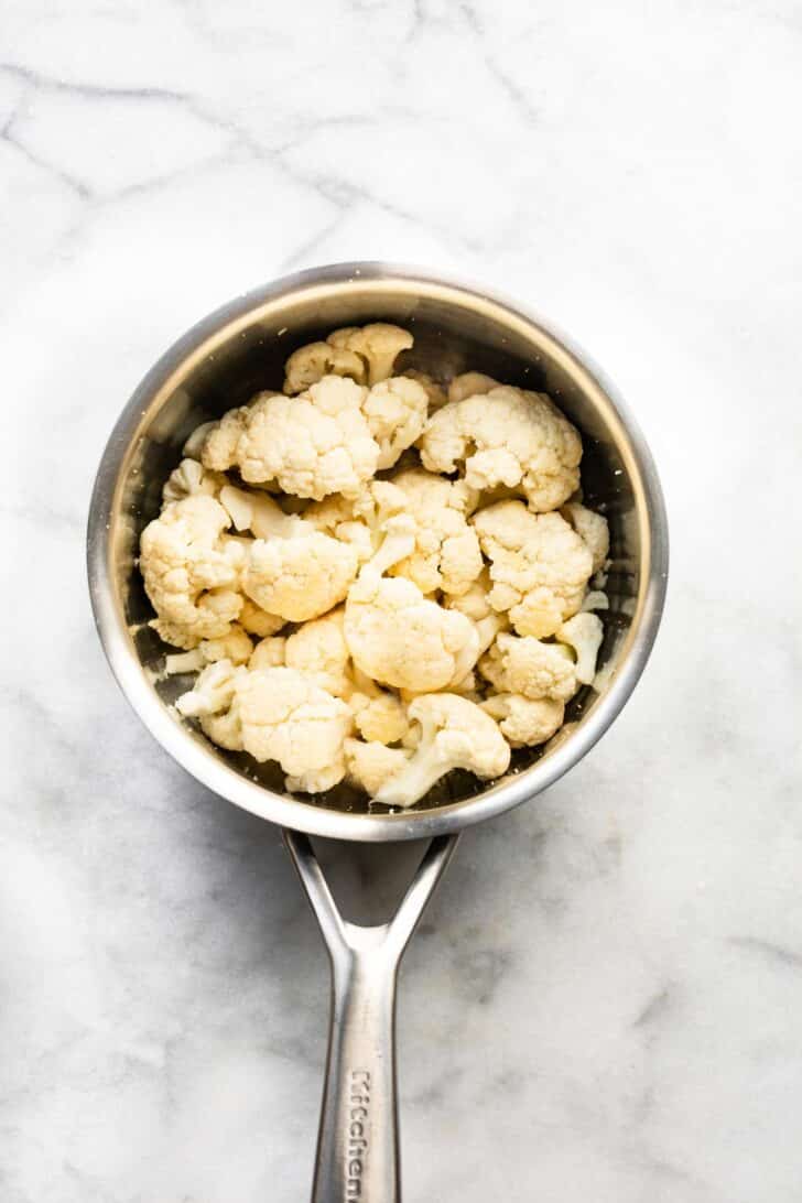 overhead photo of cauliflower floret in a pot to cook/steam