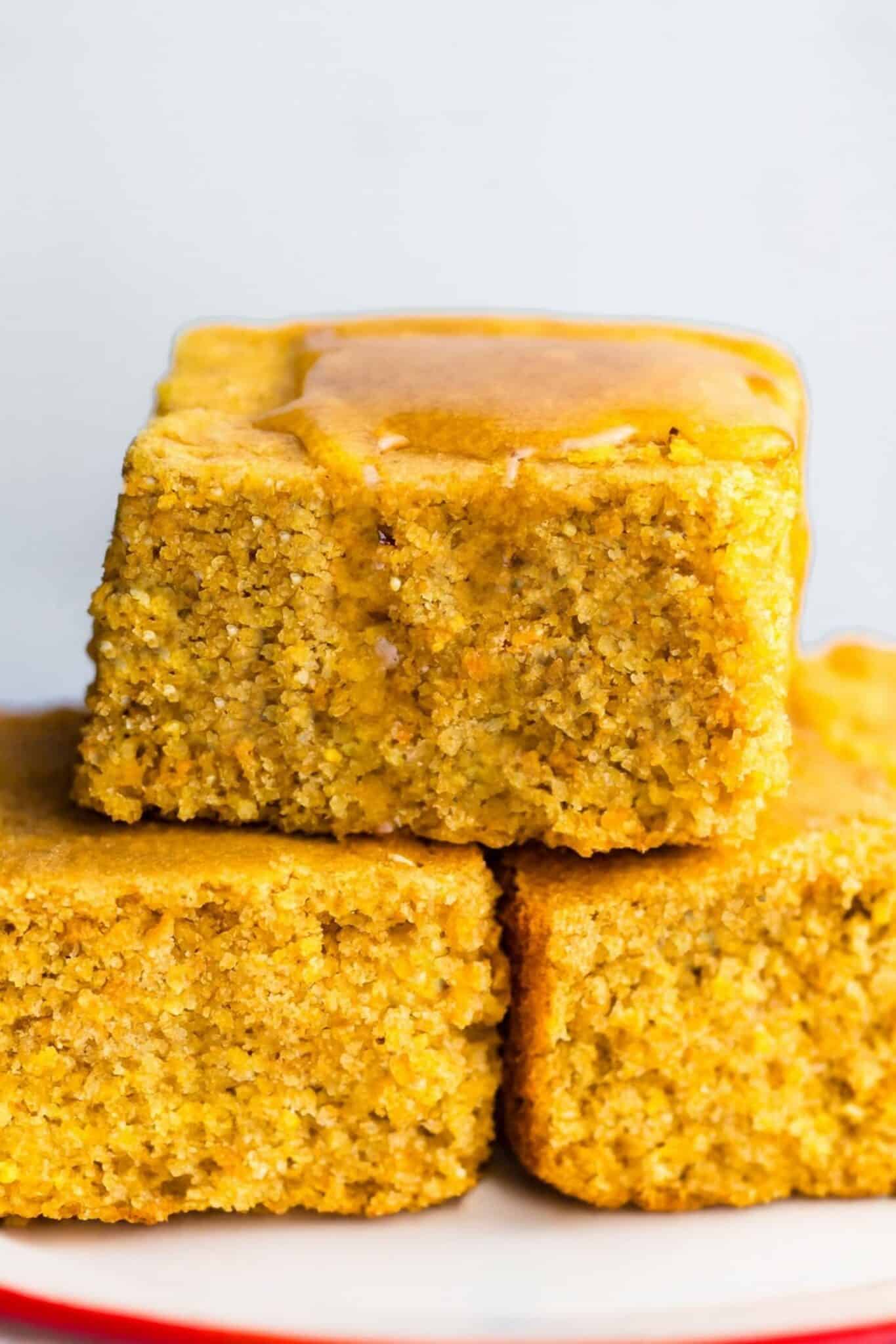Stacked squares of gluten-free cornbread with a drizzle of honey on top