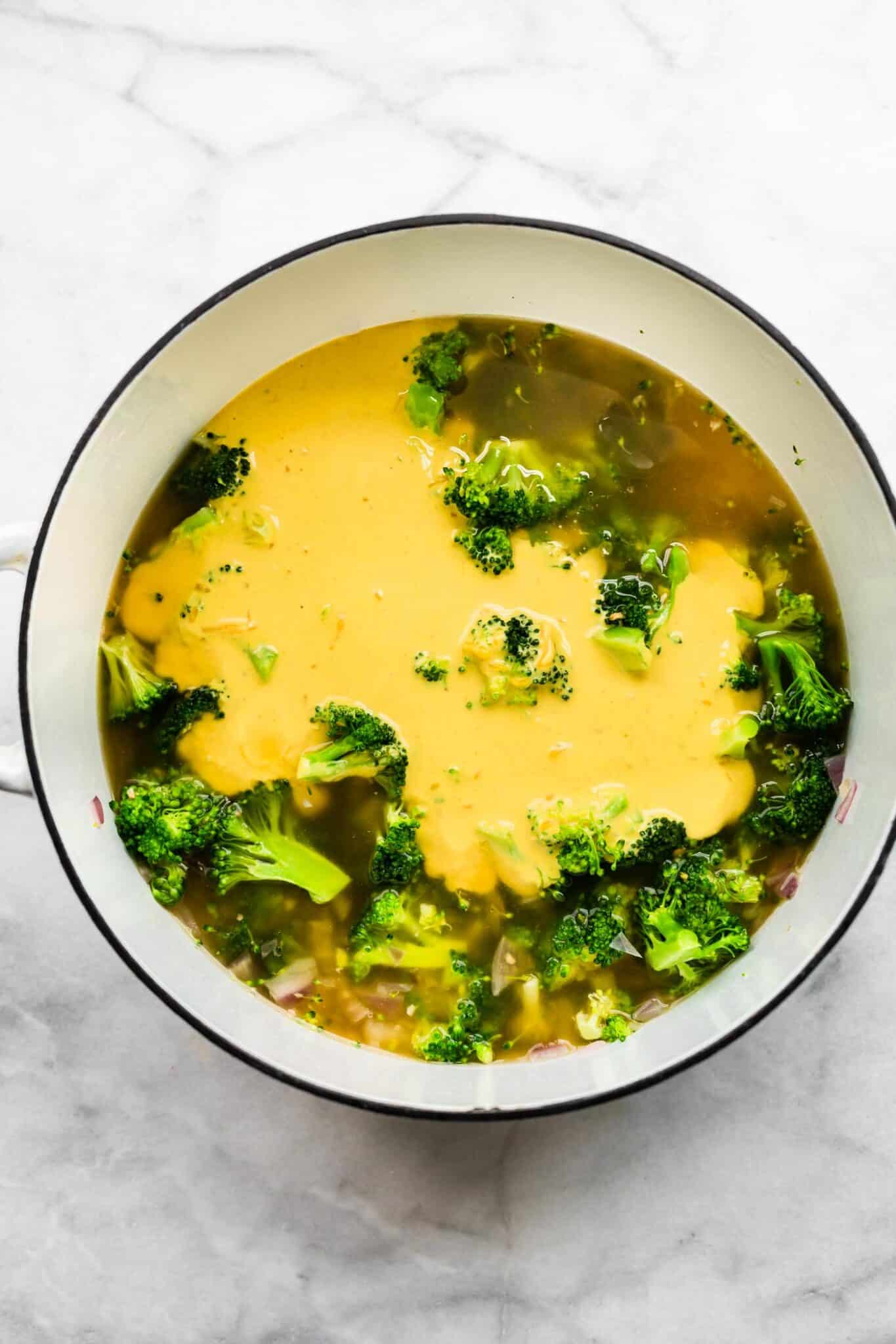 Vegan broccoli cheese soup in an instant pot topped with shredded dairy-free cheese.