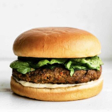 Lettuce, a veggie burger and sauce layered between a gluten free hamburger bun.