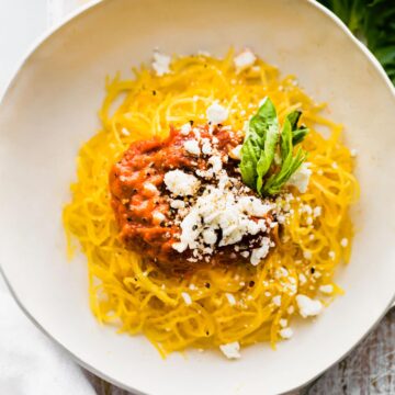 plate of Instant Pot spaghetti squash pasta with nomato sauce and dairy free Parmesan cheese
