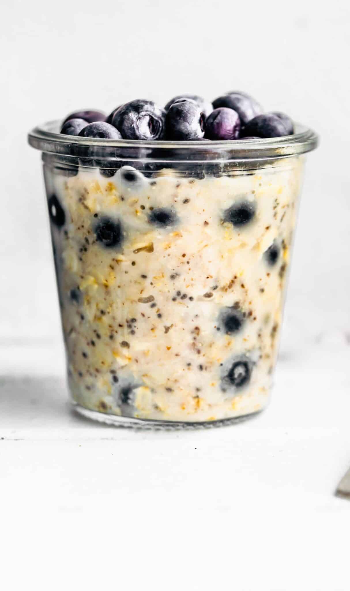 jar of blueberry overnight oatmeal and blueberries on top