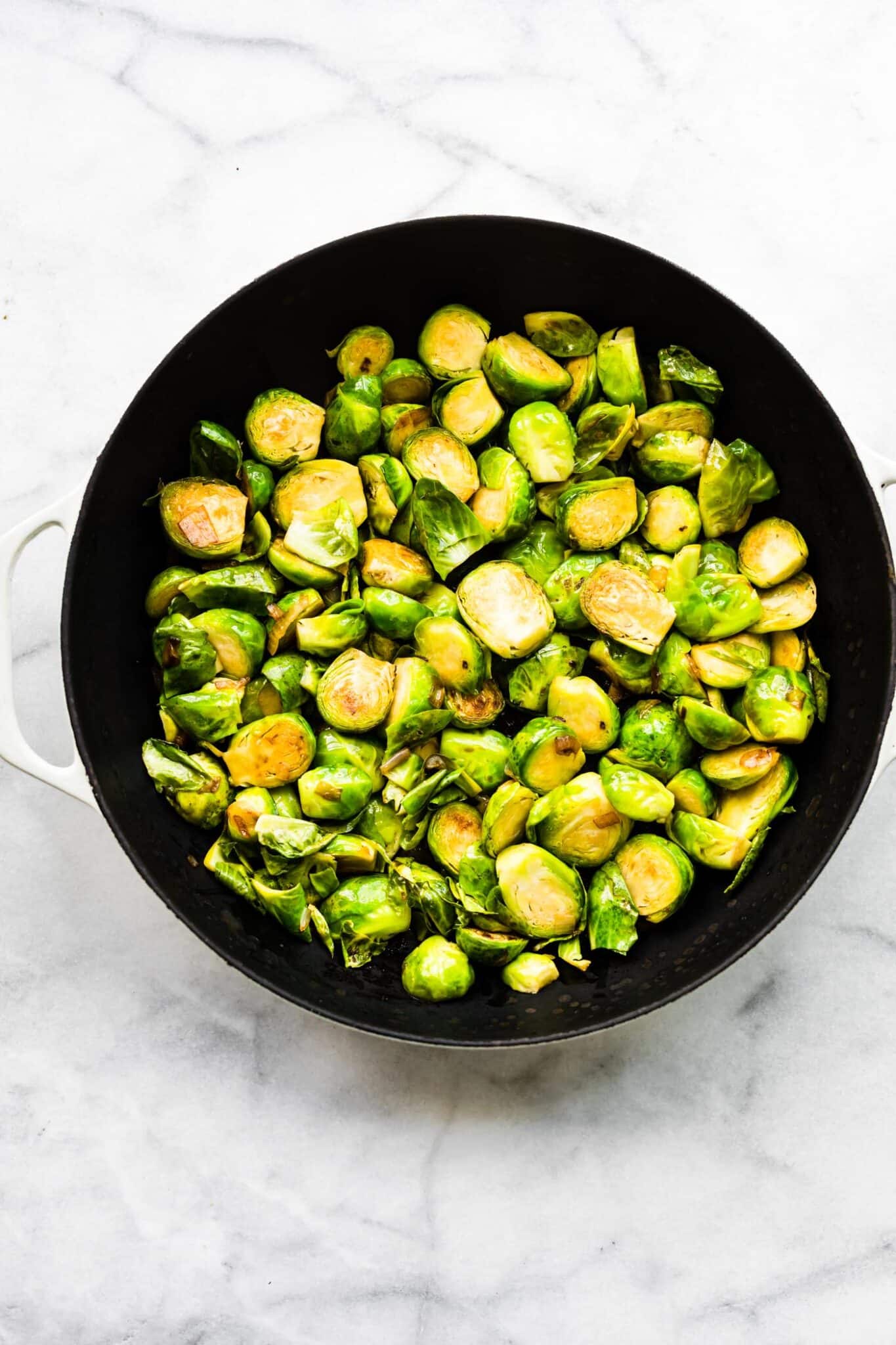 Overhead photo of roasted brussel sprouts in a cast iron skillet.