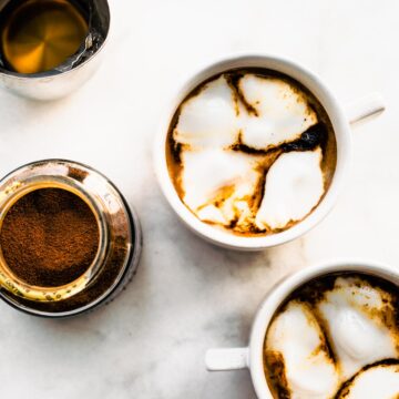 Two mugs of Espresso Con Panna on a counter top