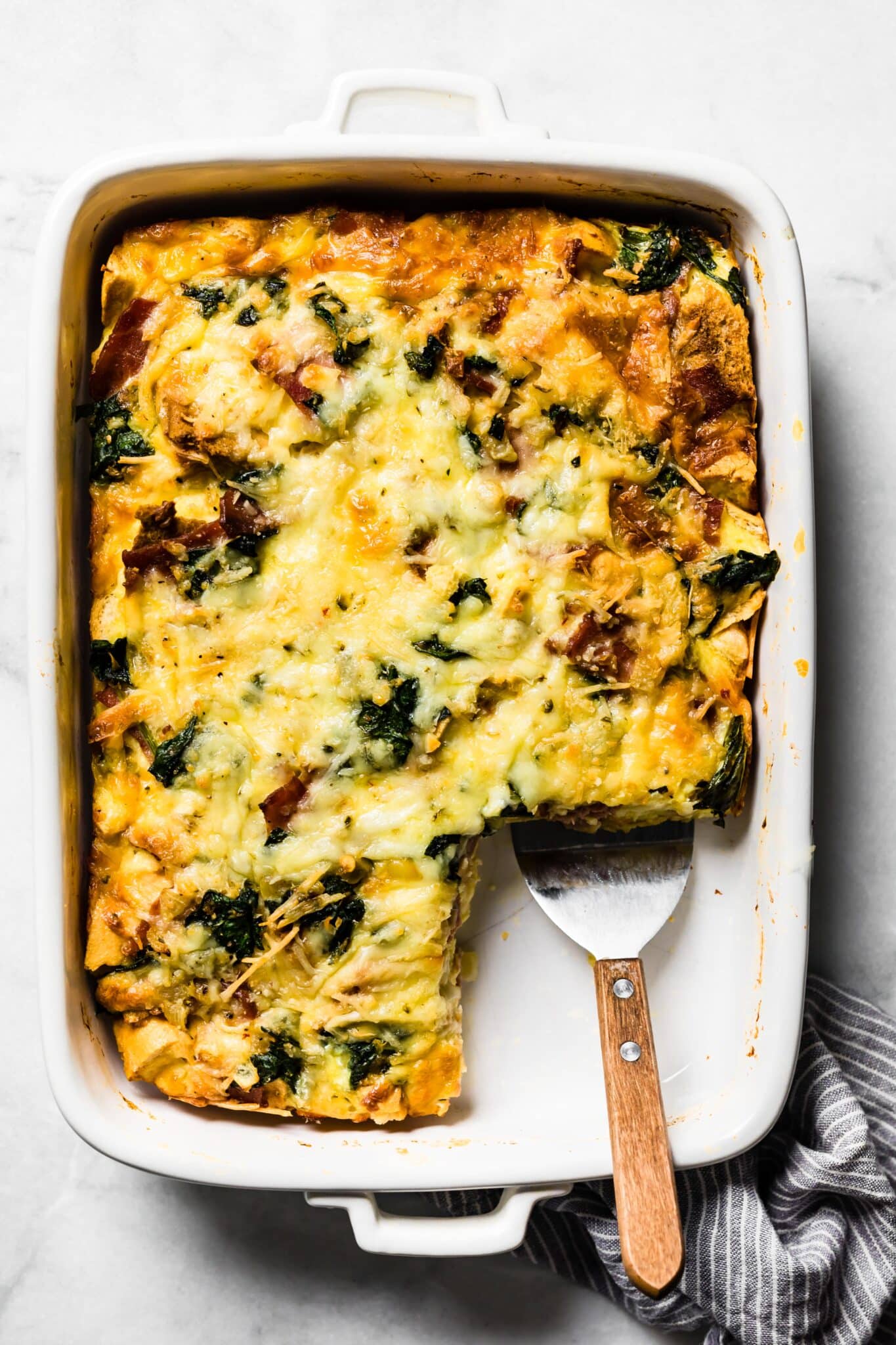 Overhead photo of a pan of gluten free breakfast strata with a slice removed.