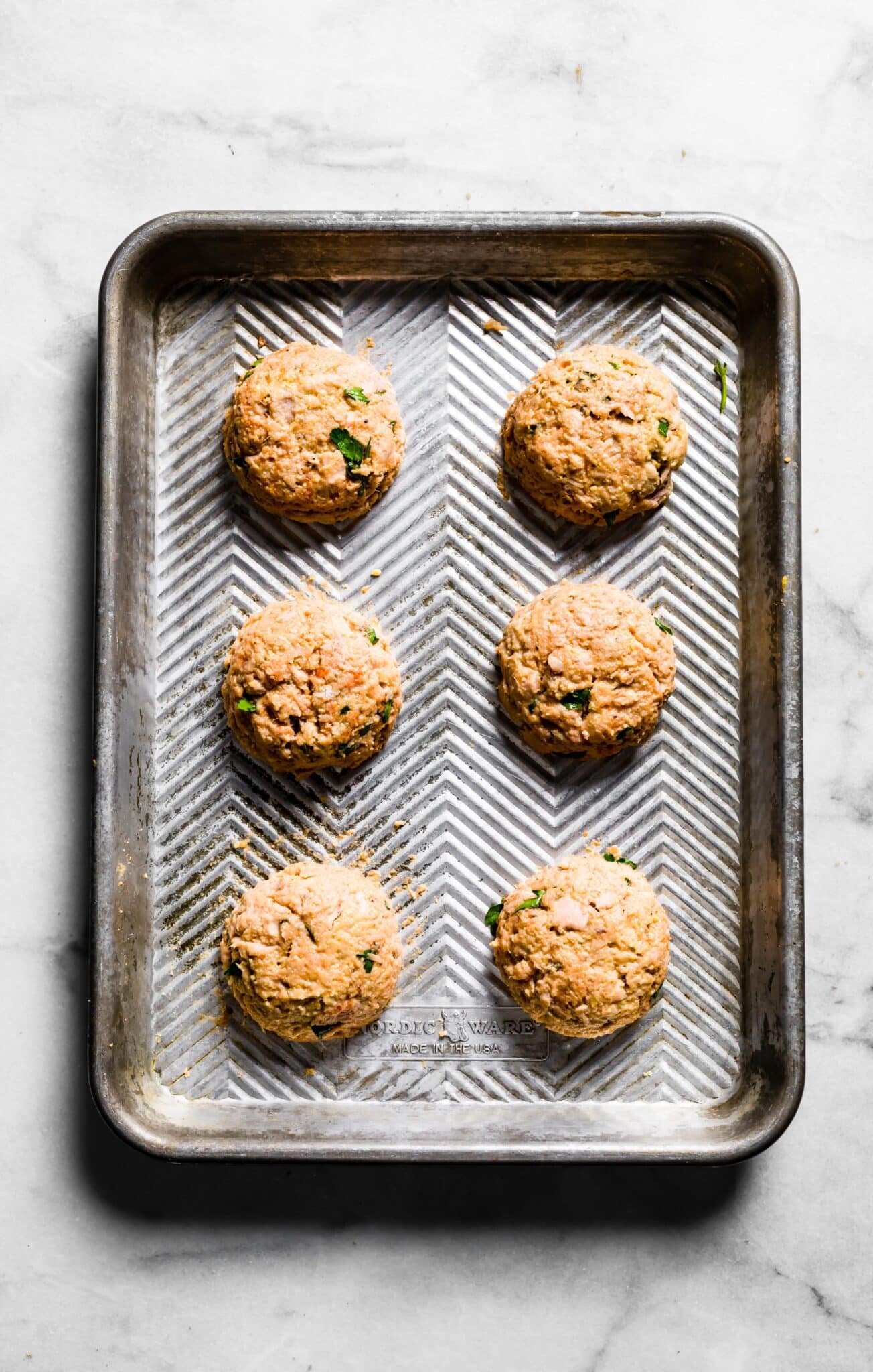 6 raw tuna patties on silver baking sheet