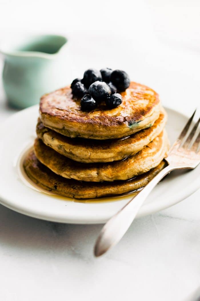 a stack of dairy free pancakes topped with fresh berries