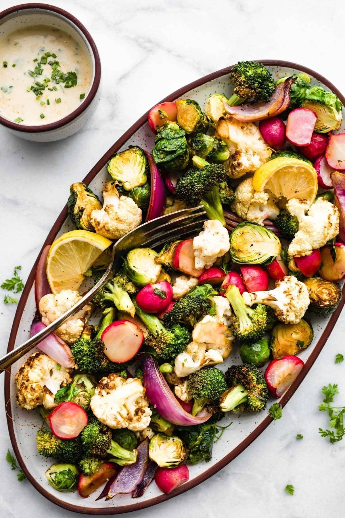 snack platter of healthy roasted vegetables next to dish of vegan ranch dressing