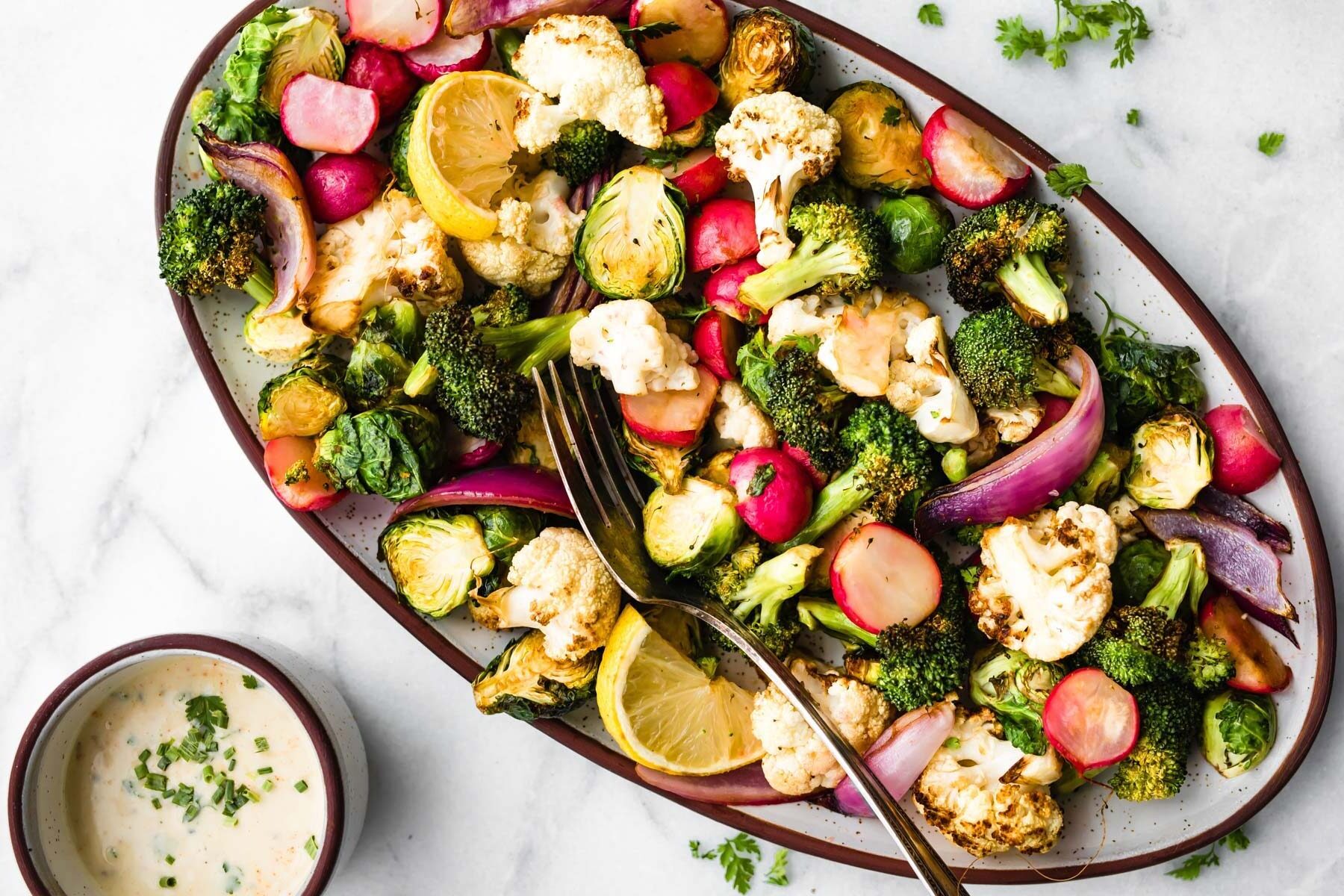 snack platter of healthy roasted vegetables next to dish of vegan ranch dressing