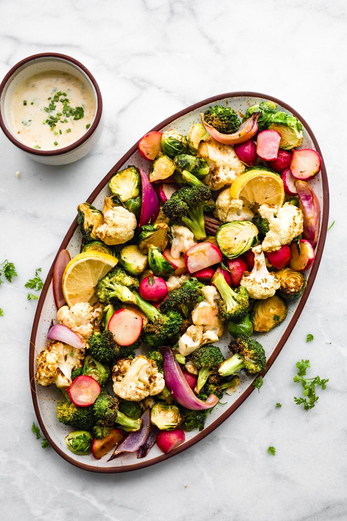 overhead image of air fried vegetables on oval platter next to spicy ranch dip