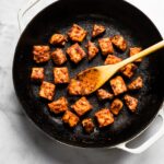 BBQ tempeh browned in a cast iron pan.