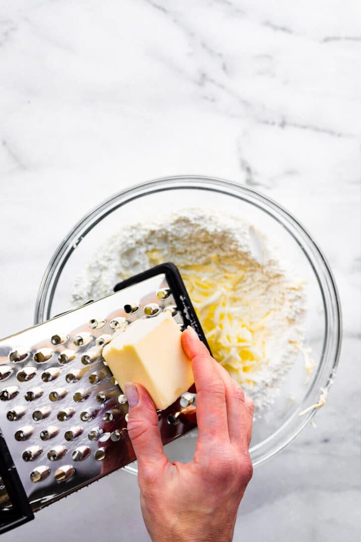 butter being grated for gluten free pie crust