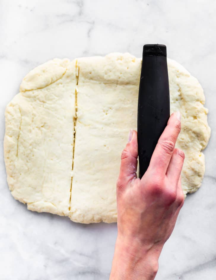 dough for gluten free biscutis being cut