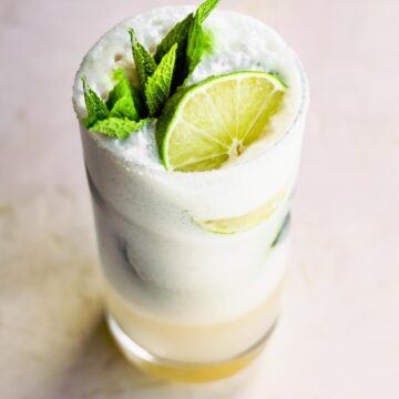 A pretty creamy coconut mojito topped with fresh mint leaves and lime slice.