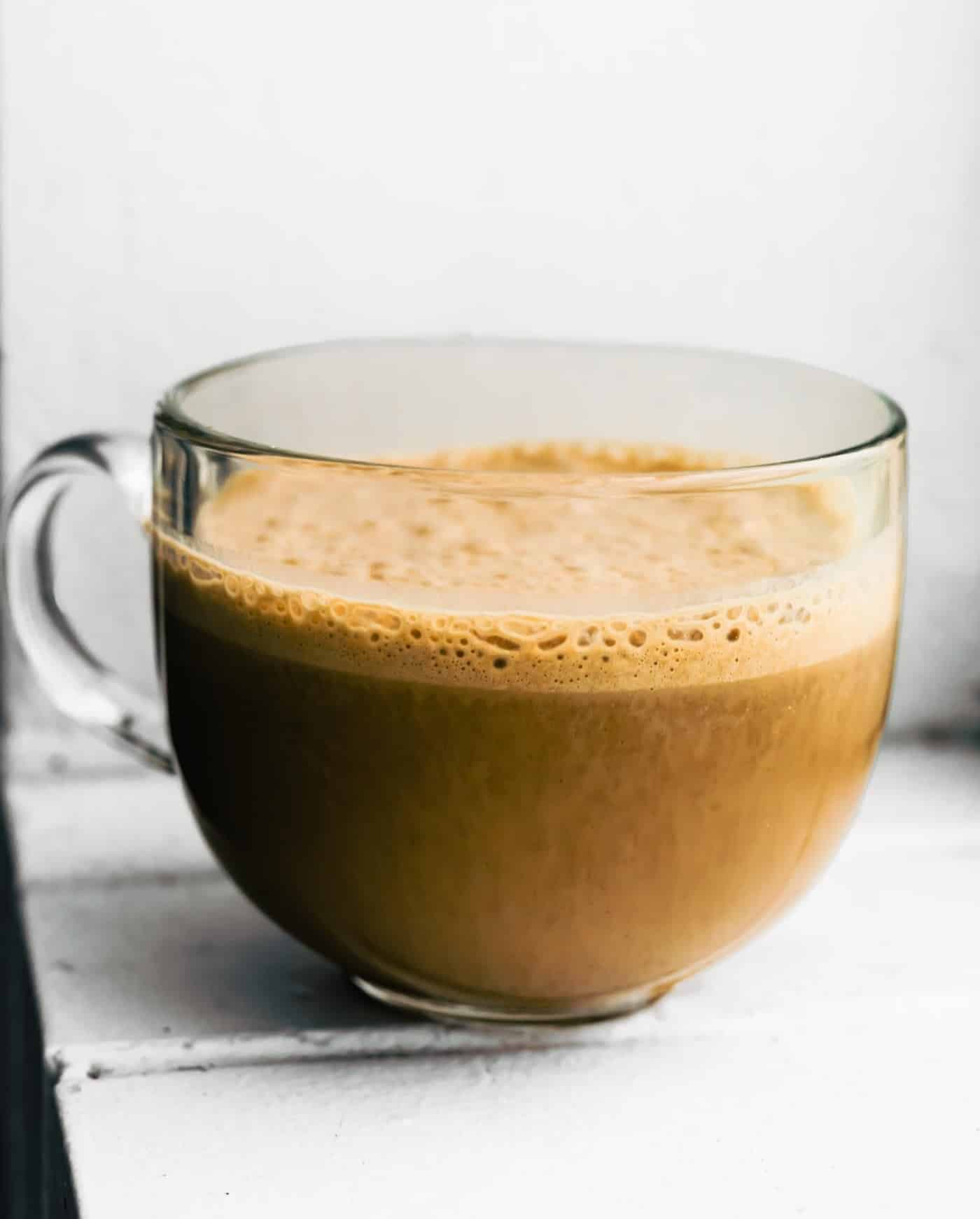 Finished banana latte in a clear glass mug