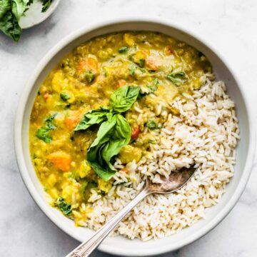 Overhead shot of a bowl of East Green Curry and rice with a spoon scooping out rice.