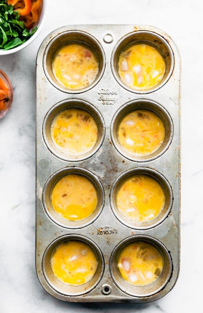 Muffin pan full of frittata egg base.