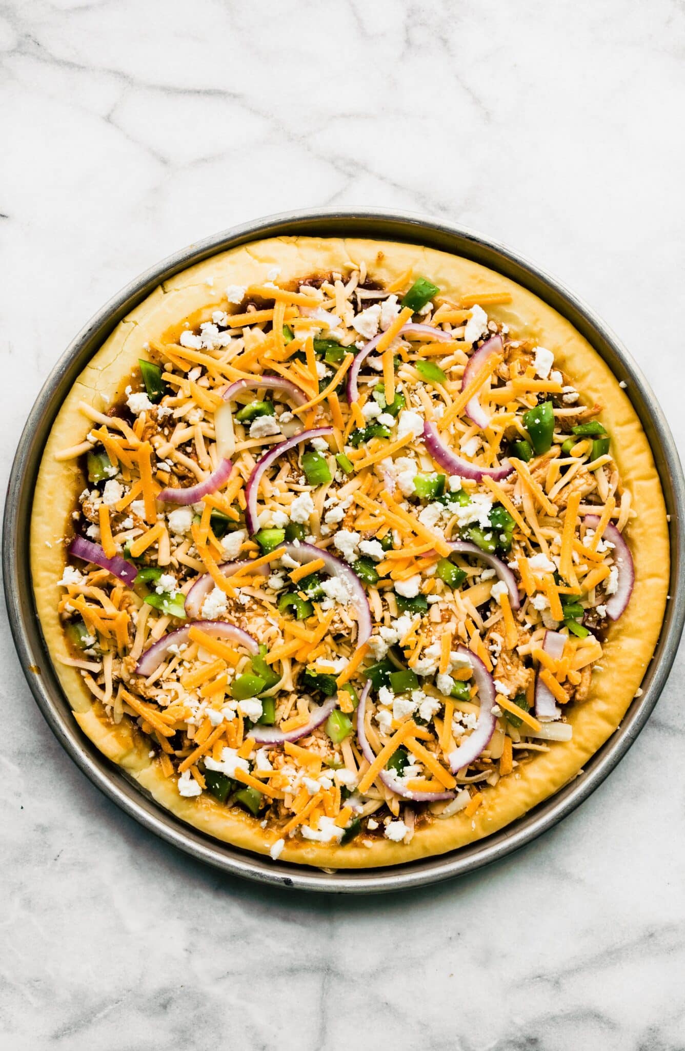 Overhead photo of a gluten free BBQ chicken pizza ready to be baked.