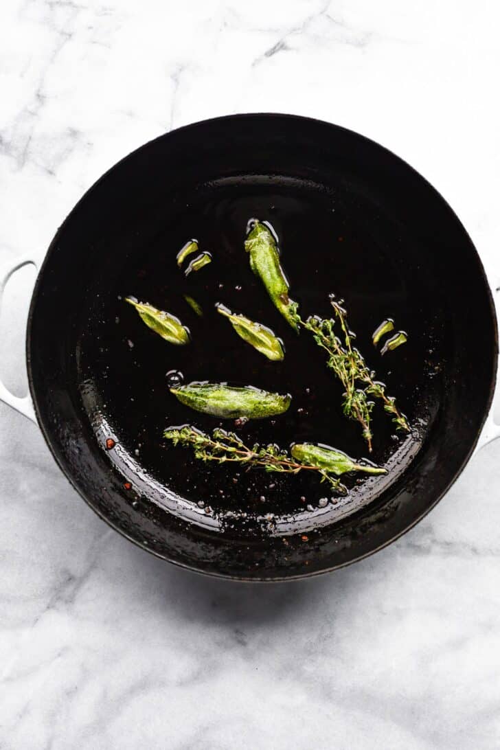 fresh sage and thyme 2. Onions and garlic sautéing in cast iron skillet