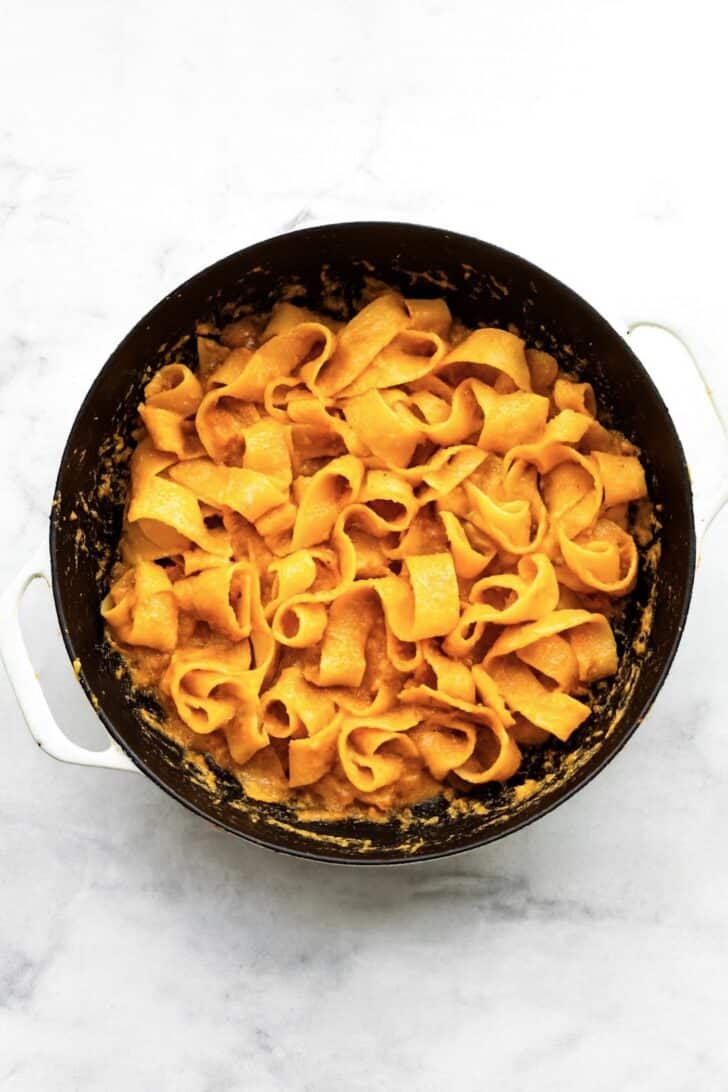Gluten-free pappardelle tossed in creamy pumpkin pasta sauce in skillet