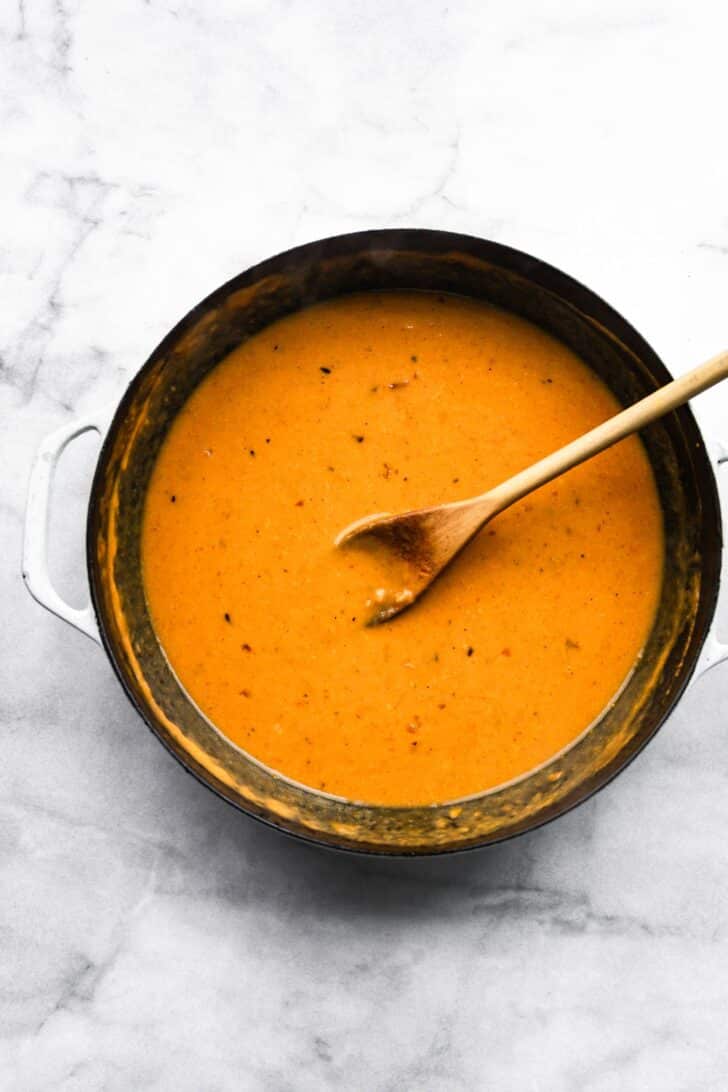 Homemade creamy pumpkin pasta sauce simmering in cast iron skillet