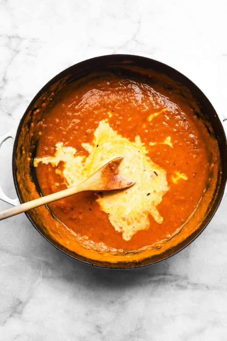 Cream being swirled into pumpkin sauce