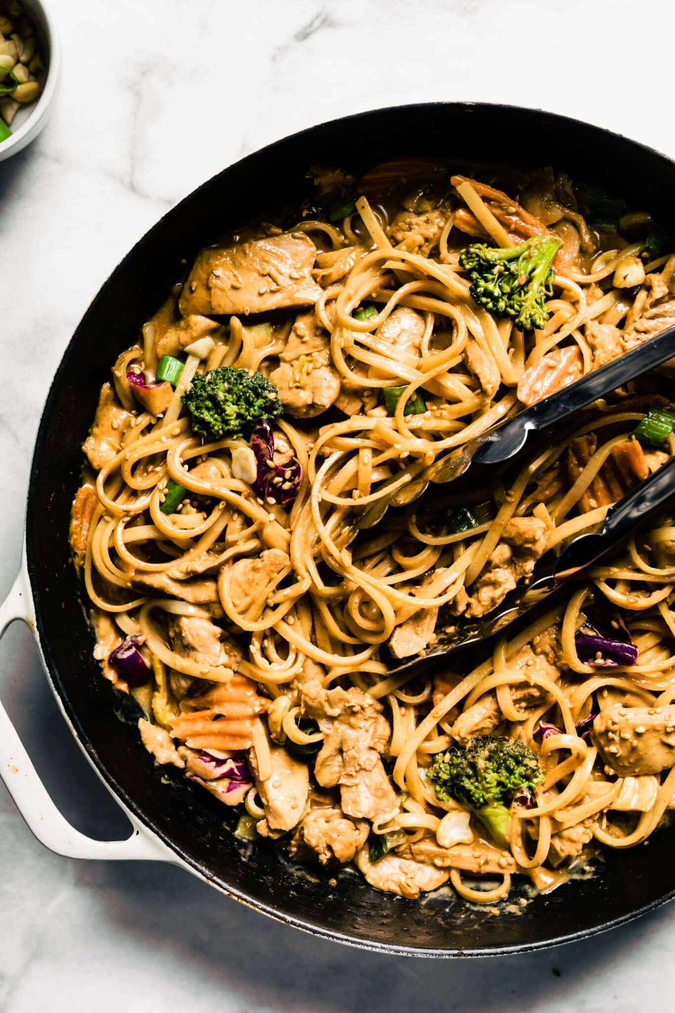 Up close overhead photo of peanut sauce noodles with veggies and chicken.